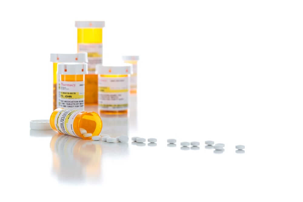 Non-Proprietary Medicine Prescription Bottles and Spilled Pills Isolated on a White Background.