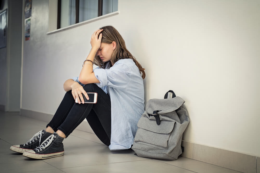 Upset and depressed girl holding smartphone