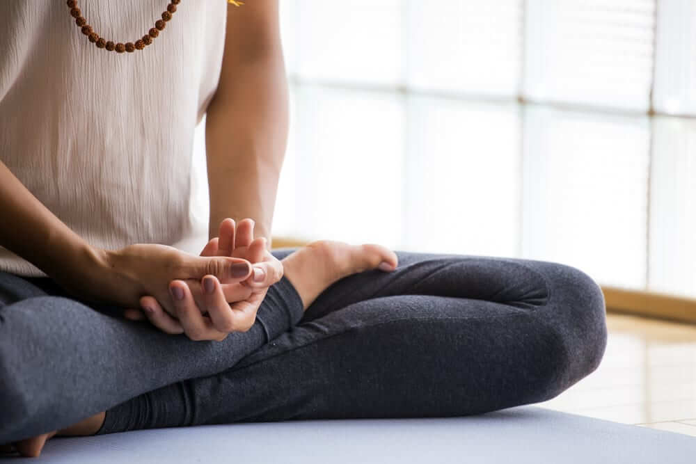 Young latin woman practicing meditation indoors.